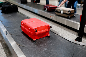 A suitcase moves along the baggage carousel at an airport. The image captures a typical moment of air travel, representing arrival, luggage claim, and the travel experience. 