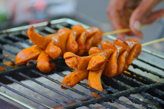 grilled sausage or sosis panggang on grill in the street food. selective focus
