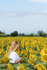 Fototapeta premium Woman in the field of sunflowers