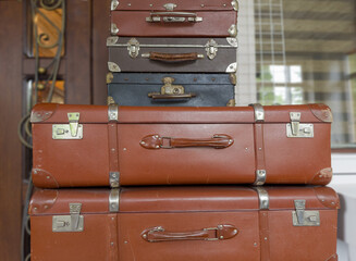 Stacked old shabby hardshell suitcases different sizes made with leatherette