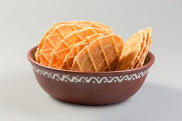 Sweet round wafers in bowl on gray background, front view