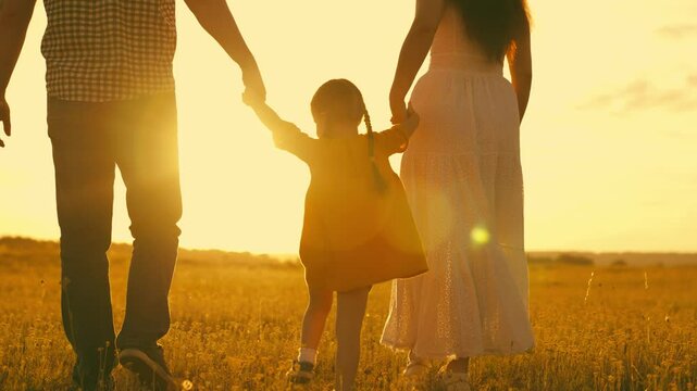 happy family park. little kid daughter runs across meadow sunset. mother father kid child travel together. childhood dream run and play. family walk sunshine. cheerful child holds mom dad by hand.