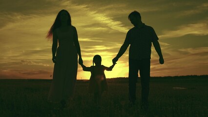silhouette affectionate parents with child sunset. happy african family sunset park. mother father hold kid hands walking against sky. cheerful multicultural family. child kid nature. travel outside