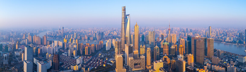Aerial view of Shanghai skyline with winding river at sunrise.