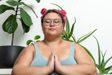 Woman meditating at home with eyes closed