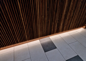 Notched design of triangular profile wooden planks on the wall of the shop. Under the overhang is...