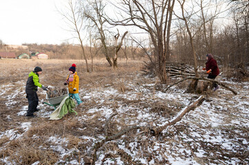 Families gathering firewood in a snowy field during winter, creating memories and bonding through outdoor activities in the rural countryside