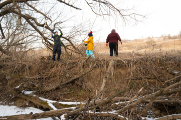Exploring the riverside in wintertime as three friends enjoy nature and camaraderie during a chilly afternoon adventure in the countryside