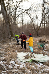 Community members gather in the forest during winter to collect firewood, fostering teamwork and connection with nature while preparing for the cold season ahead