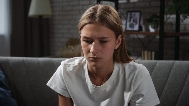 Young Woman in Thoughtful Pose on Comfortable Sofa