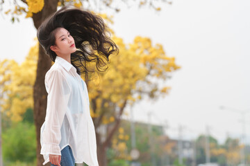Joyful girl smiling amidst golden autumn leaves outdoor nature scene cheerful vibes