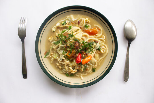 Mie godog Jawa or bakmi jawa or java noodle or Mie rebus or boiled noodles with spoon and fork. Indonesian traditional street food noodles from java, indonesia on white backgroud