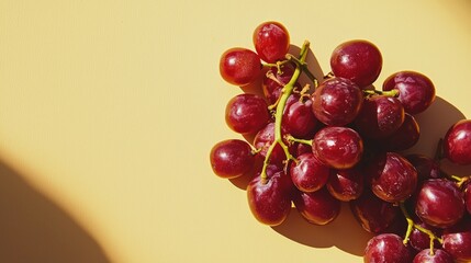 Hand holding red grapes with yellow background colorful fruit healthy food snack natural sweet organic