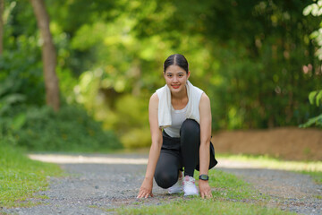 Portrait of a beautiful young female athlete sitting, ready to run.