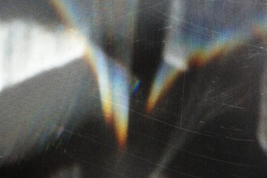 scratched vintage glass texture with iridescent rainbow light refraction, abstract grunge overlay for digital art and design