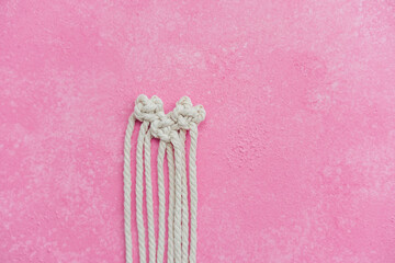 Obraz premium Macrame heart in progress on pink background