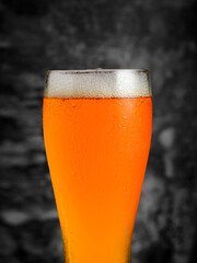 Close-up of a condensation-covered glass of amber ale, showcasing its vibrant color and creamy head