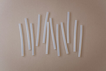 Transparent glue sticks arranged on brown background