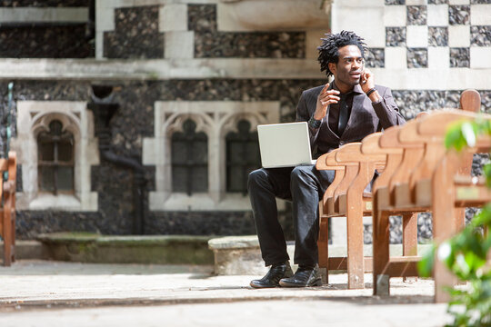 Working Lunch. A young business professional taking a phone call while working out of the office during his lunch break. From a series with the same model. - Powered by Adobe