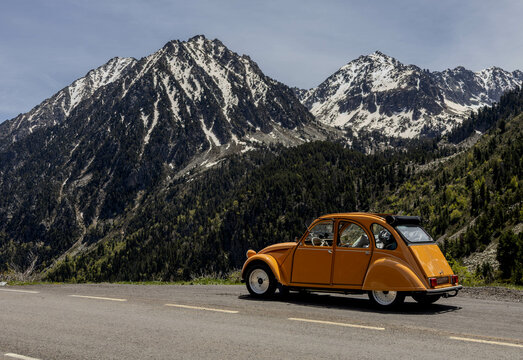 Vintage Citro&euml;n 2CV with snow-covered mountain in the Pyrenees