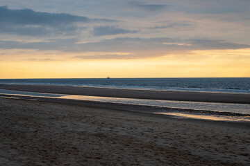 Sea, sky, sand, boat on the beach. Alone by the sea at sunset.