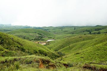 Scenic landscape of rolling hills and green valleys in a rural area during overcast weather