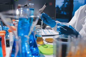 Scientist pipetting medical samples into microplate in laboratory