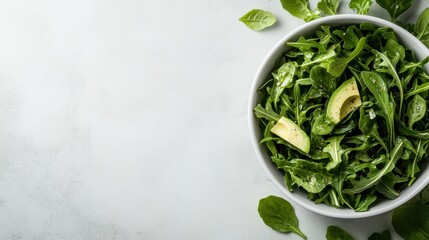 Obraz premium A healthy green salad featuring fresh spinach, arugula, and avocado slices, perfect for a nutritious meal or a fresh side dish.