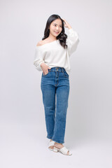 Full body portrait happy smile young asian beautiful woman curly hair wearing long sleeved shirt, blue jeans outfit, casual standing pose on white background joy positivity fashion lifestyle concept.