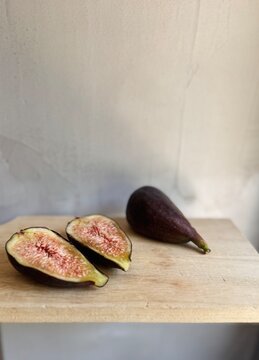 Fresh breva fig pieces on wooden board.