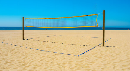 Empty beach volleyball court under bright sunlight with smooth sand and blue sky