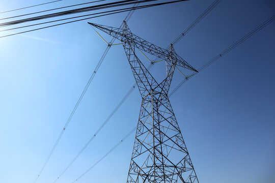 "High voltage transmission towers. the pylon outline Very High Voltage Power Lines (Indonesia : SUTET) on blue sky"
