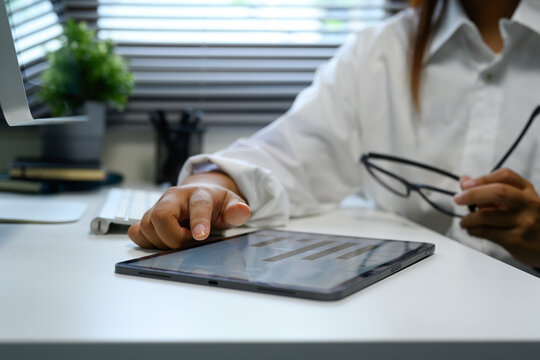 Close up of businesswoman using a digital tablet on a white office desk