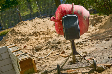 Construction electric mini concrete mixer on sand. Portable cement