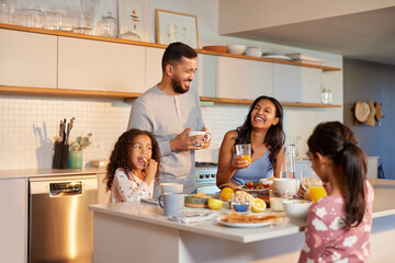 Mixed race family with two children enjoying breakfast at home