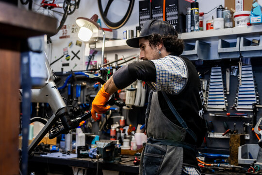 Bicycle mechanic repairing modern bike in workshop