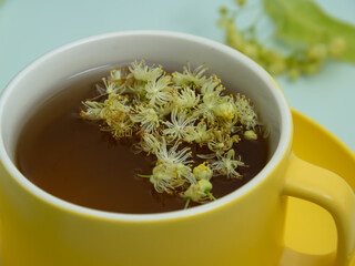 ime tea in a yellow cup with lime flowers