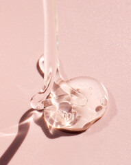 cosmetic sample of transparent gel texture on pink background