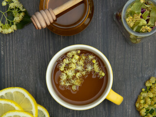 Phytotherapeutic composition of lime tea and honey on a wooden table. A healthy herbal drink.