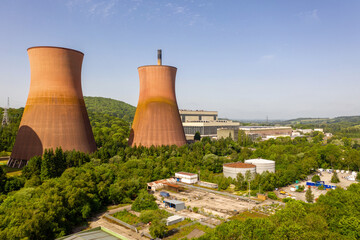 Aerial View of Industrial Cooling Towers and Power Plant Surrounded by Green Forested Hills
