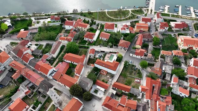 Historic coastal town Nin captured by drone in spring. Old town Nin with stone houses and Adriatic backdrop filmed from above, showing heritage and coastal charm in springtime Croatia