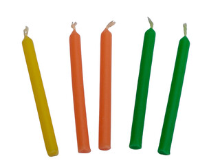 Five colorful wax candles in yellow, orange, and green with unlit wicks, arranged upright.