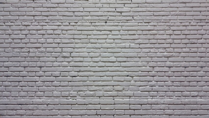 Fototapeta premium A fire hydrant standing in front of a white brick wall, ready for use