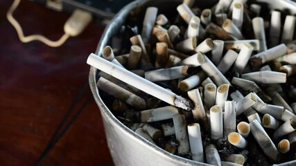 Extinguish a cigarette in an ashtray full of butt cigar stop smoking concept unhealthy lifestyle 4k