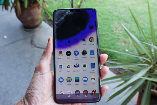 Person holding Smartphone mobile screen bleeding blue and black. Touch screen damage broken and burnt internal hardware spoilt