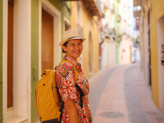 Woman in dress strolls through colorful streets of Spanish coastal town of La Vila Joiosa or...