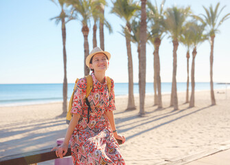 Woman in dress strolls through colorful streets of Spanish coastal town of La Vila Joiosa or...