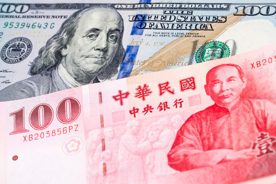 100 US dollar and 100 New Taiwan dollar banknotes. International trade concept