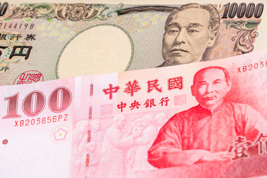 10000 Japanese yen and 100 New Taiwan dollar banknotes. International trade concept