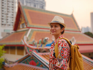 Naklejka premium Woman Exploring Colorful Streets Near Buddhist Temples in Bangkok